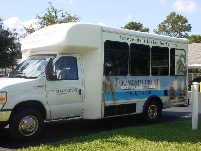 White Fountain Crest bus parked outdoors with Independent Living for Seniors sign