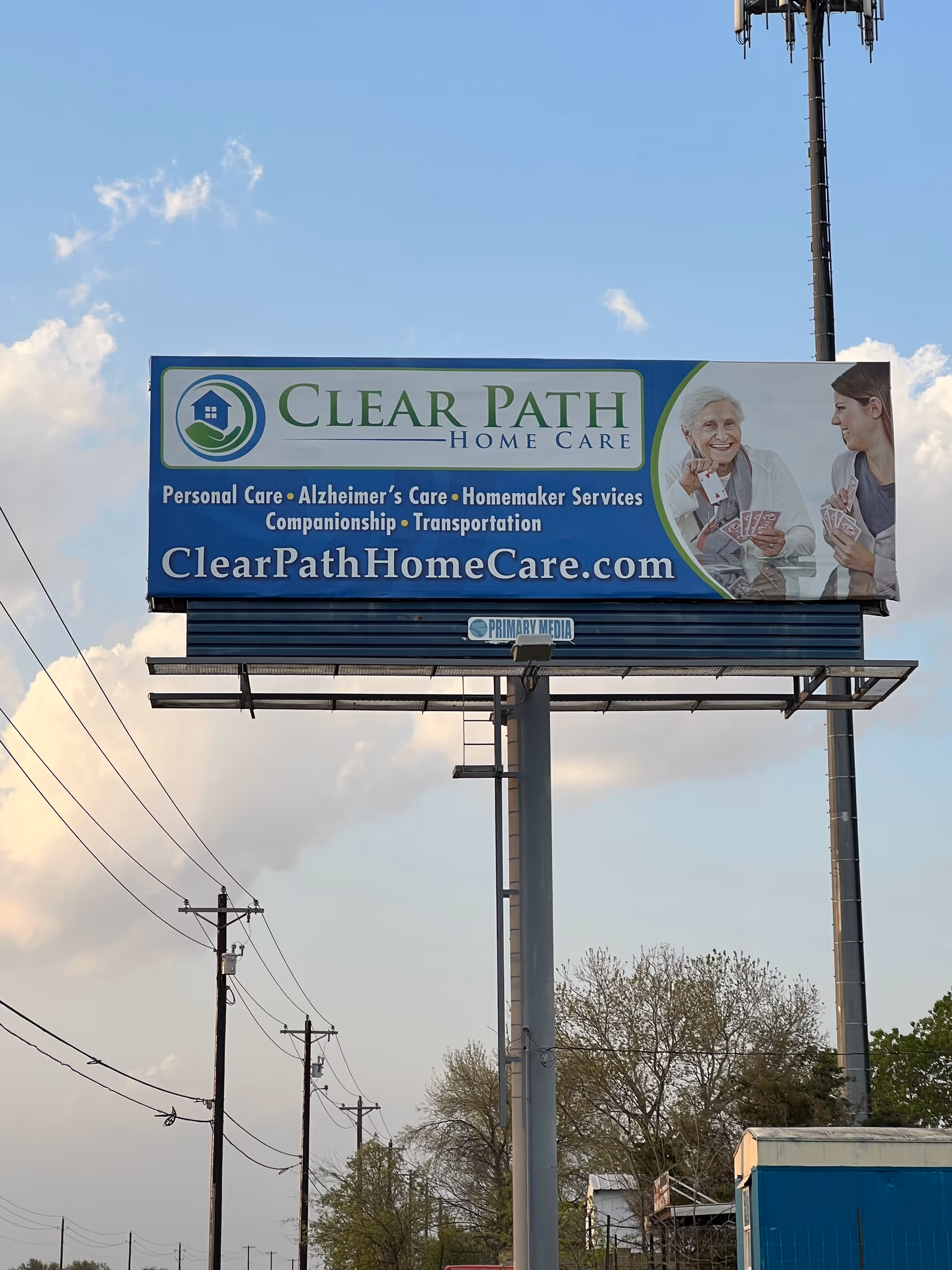 A large Clear Path Home Care billboard mounted on a tall pole beside power lines.