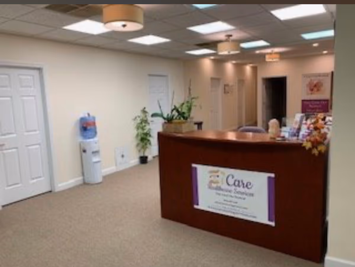 iCare Home Healthcare Services reception desk in a bright plant-filled lobby.