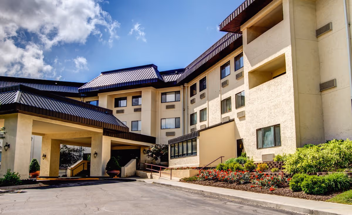 Exterior view of a multi-story senior living building with landscaped entrance.