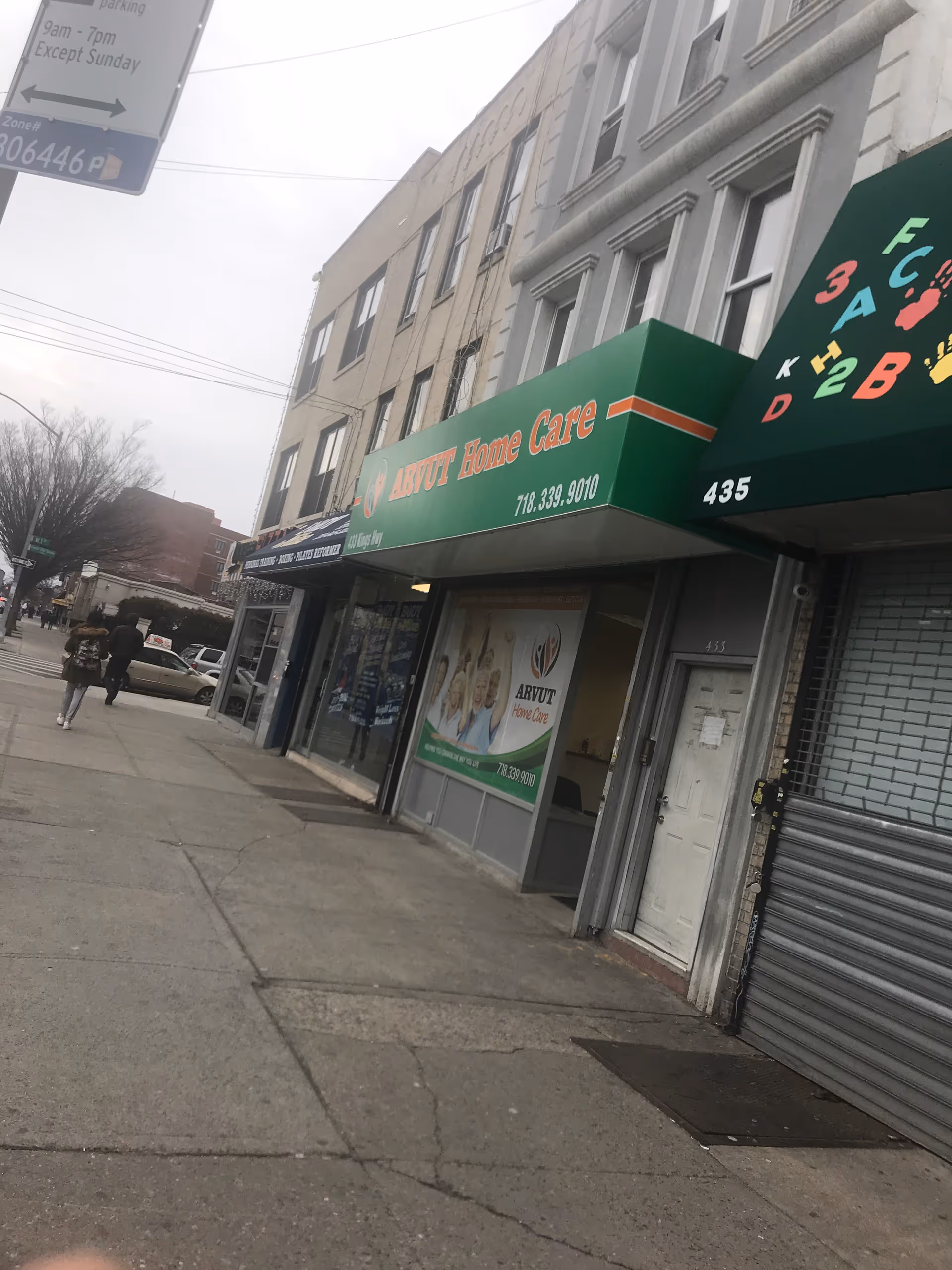 Street view showing Arvut Home Care storefront with green awning on a city block and pedestrians.