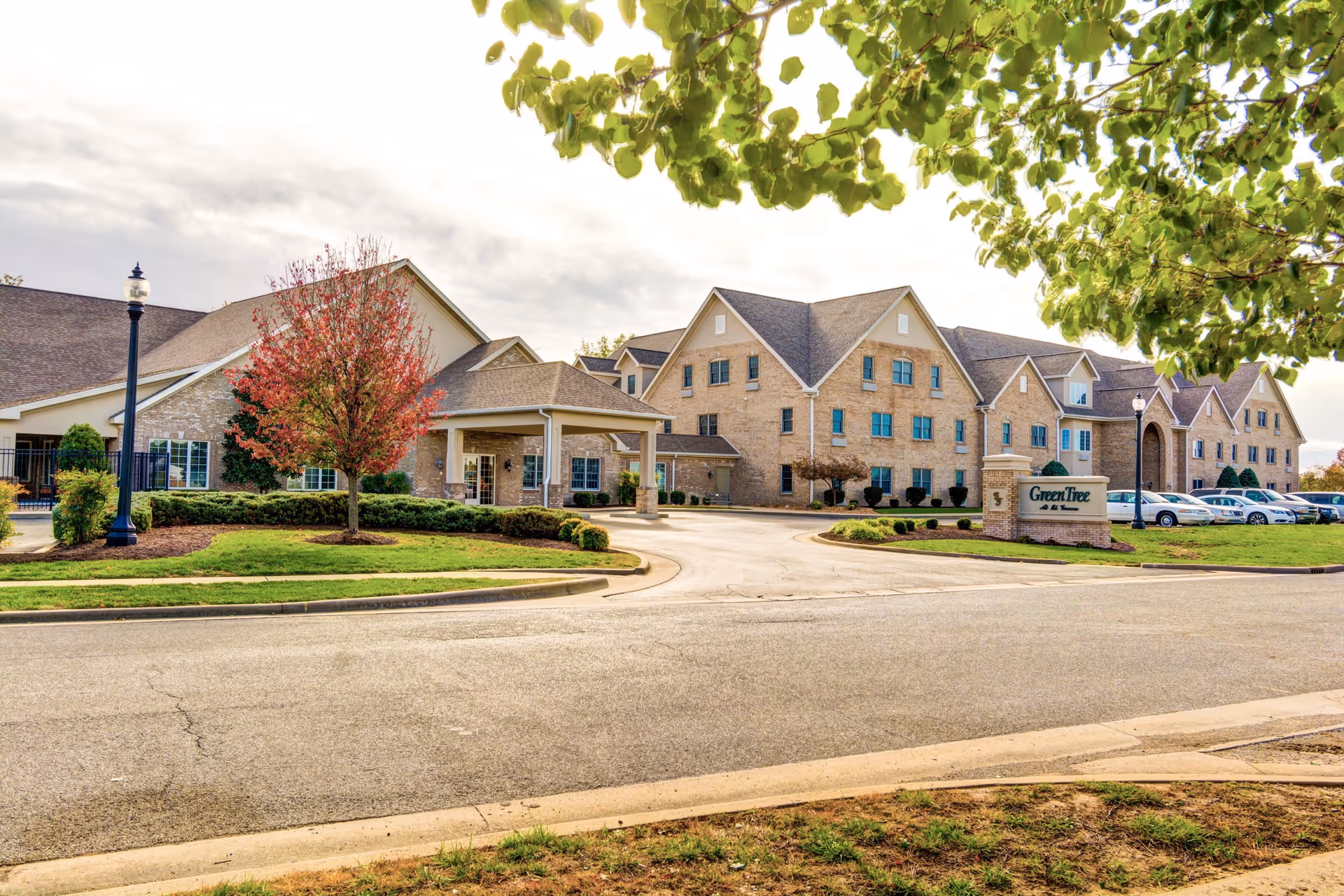 Front exterior of the GreenTree at Mt. Vernon senior living building with a driveway, entrance canopy, and landscaped grounds.