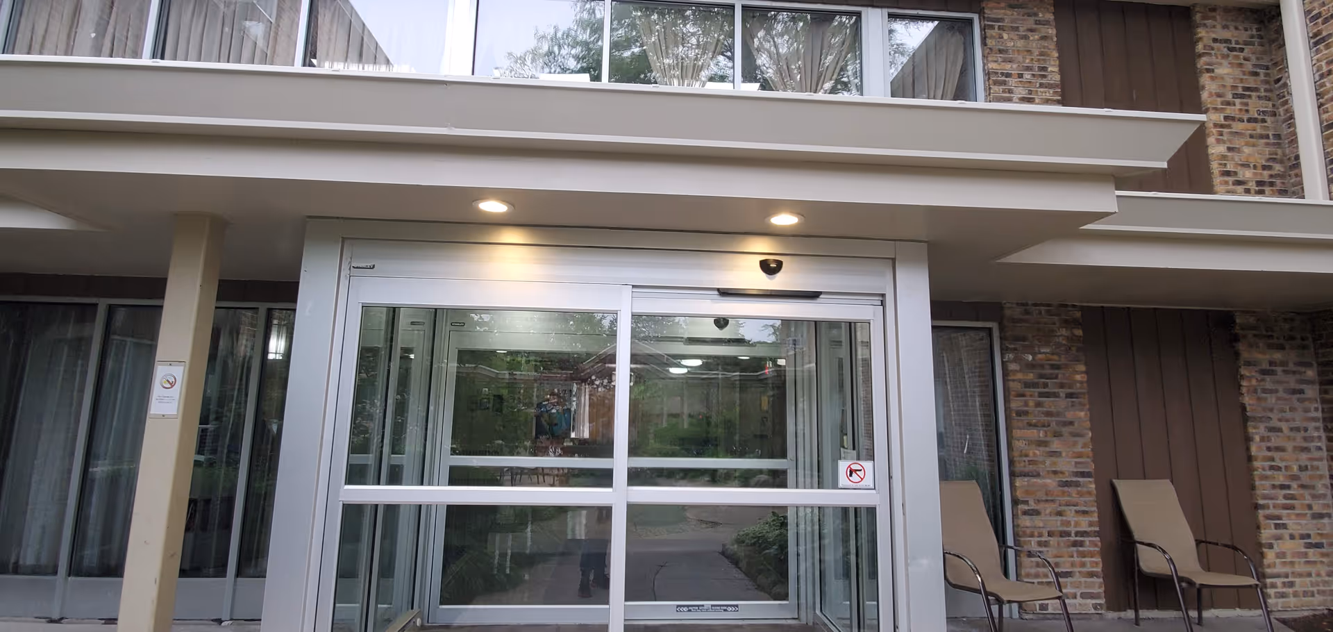Zahav of Berwyn building entrance with glass doors and outdoor chairs.