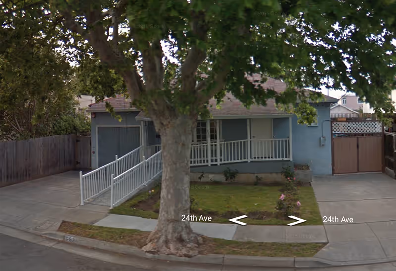 Front exterior view of Heritage Place with a tree, ramp, and driveway.