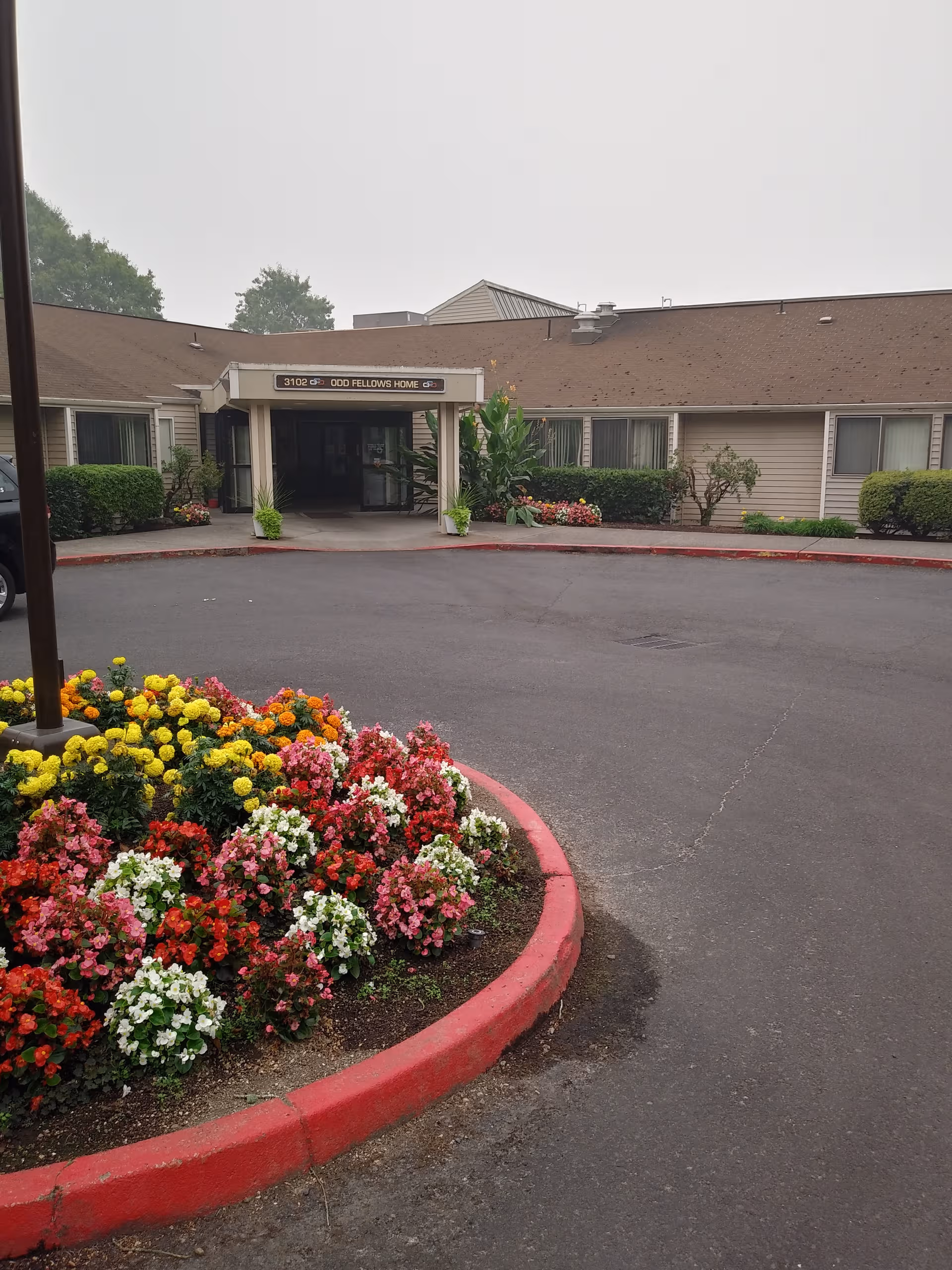 Exterior entrance of Holgate Center with a vibrant flower bed in the foreground