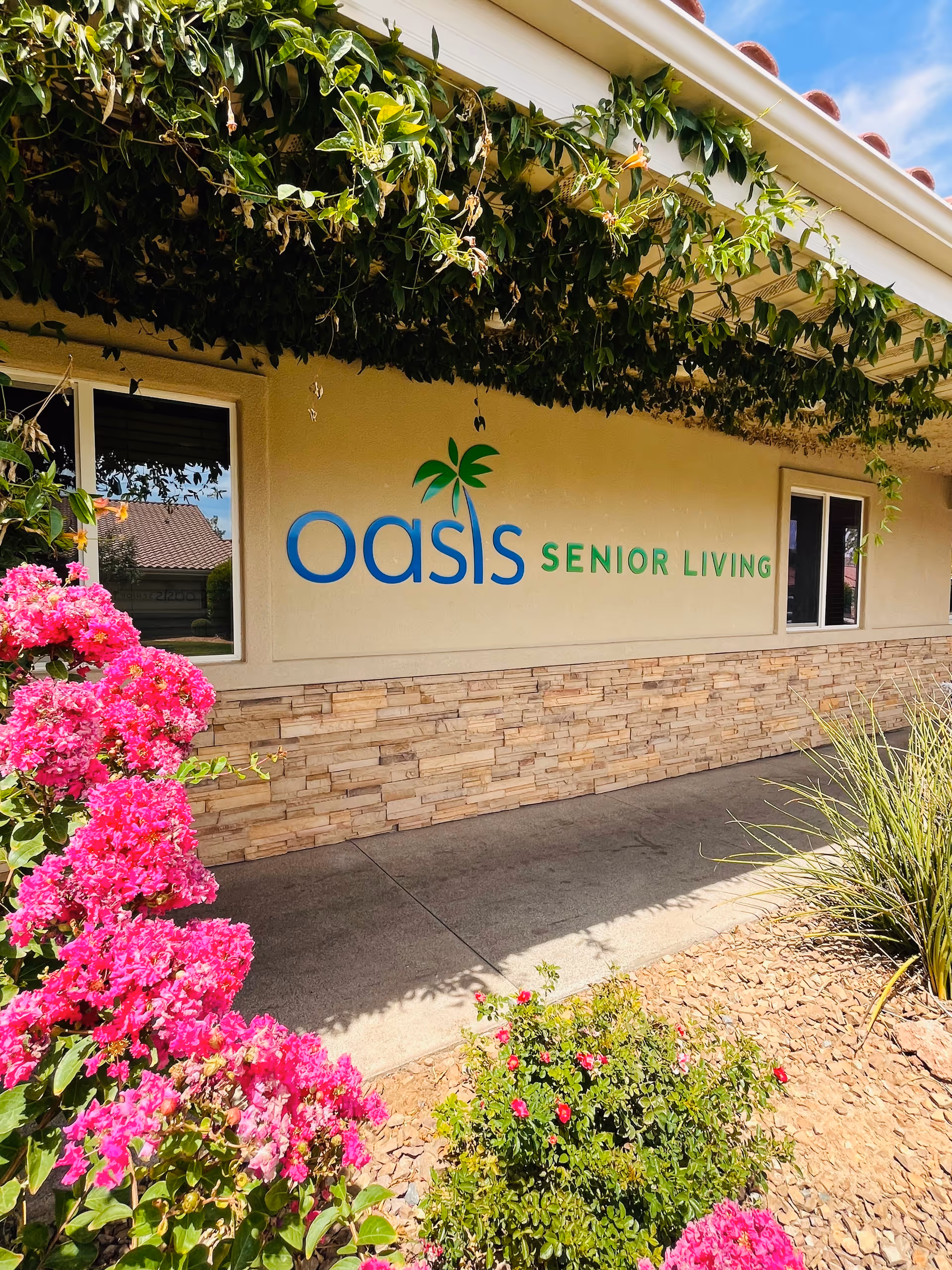 Exterior view of a senior living facility with Oasis Senior Living signage.