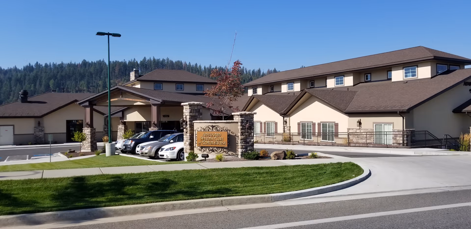 Exterior view of Advanced Health Care of Coeur D'Alene facility with parking and sign.