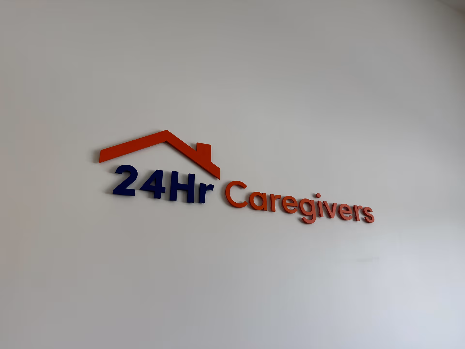 Interior wall displaying a red roof logo and the words 24Hr Caregivers.
