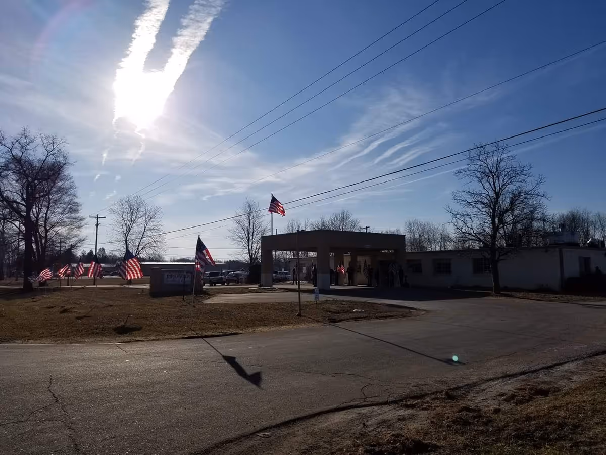 Exterior view of Ovid Health Care Center with flags at the entrance.