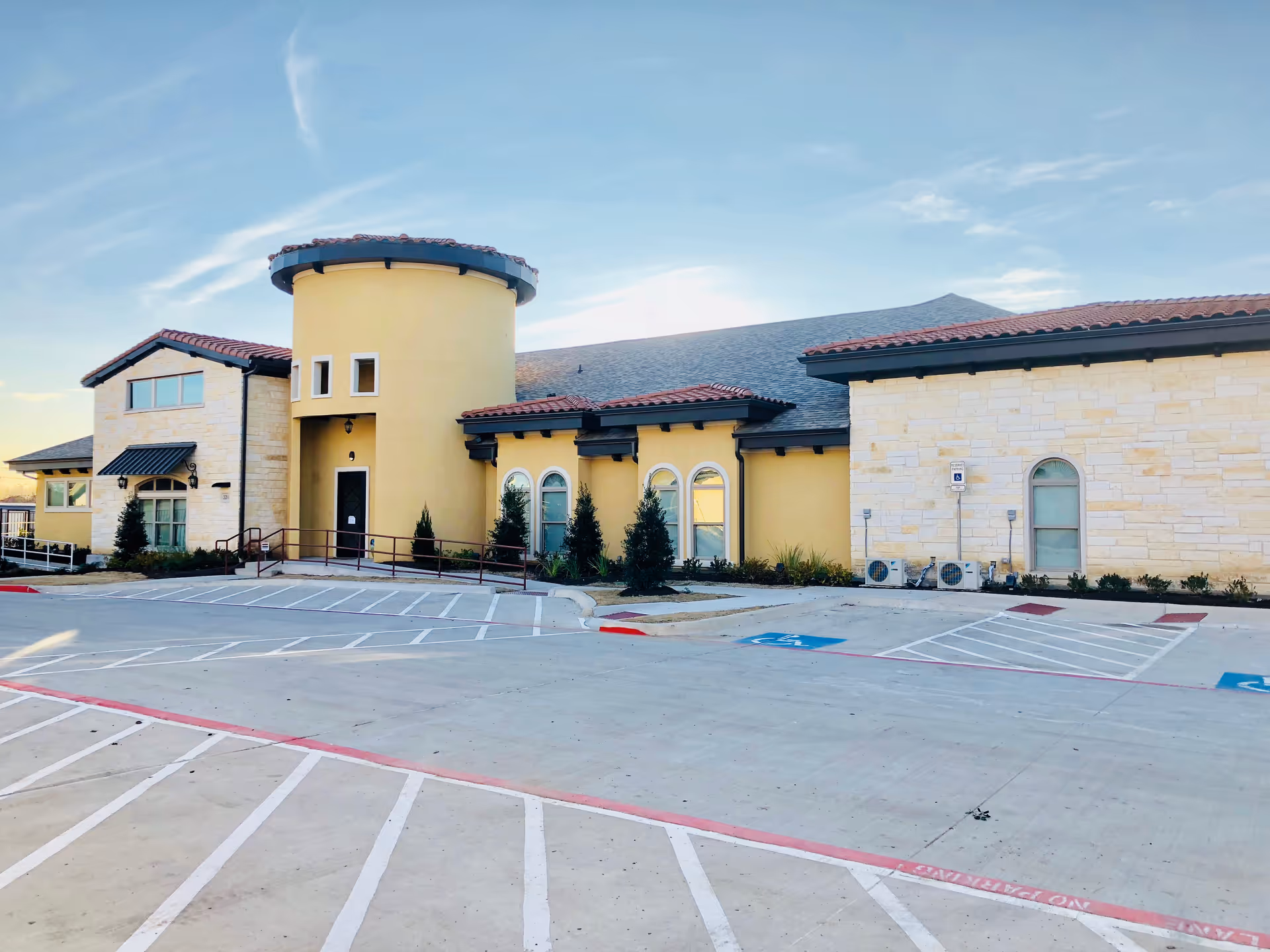 Exterior view of Magnolia Assisted Living and Memory Care building with a spacious parking lot