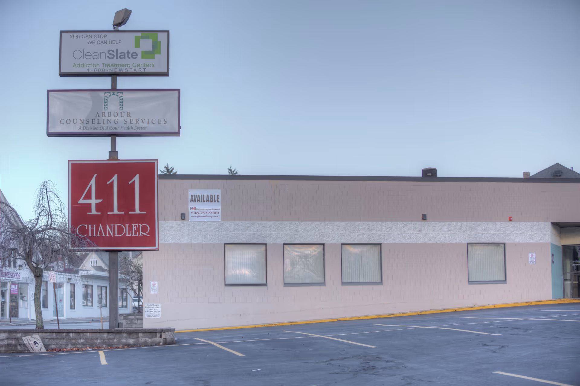 Exterior view of a beige commercial building with Arbour Counseling Services and 411 Chandler signage.