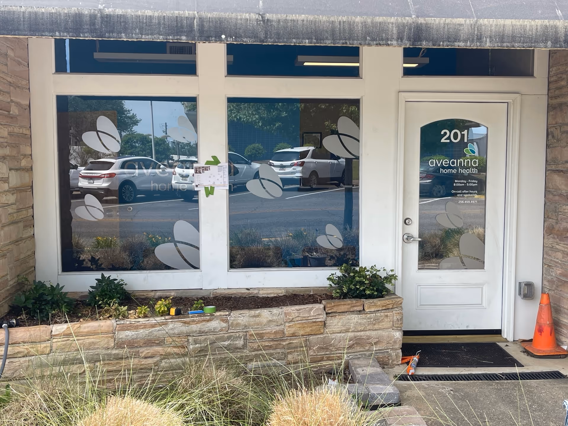 Storefront of Aveanna Home Health with glass doors and windows facing a parking lot.