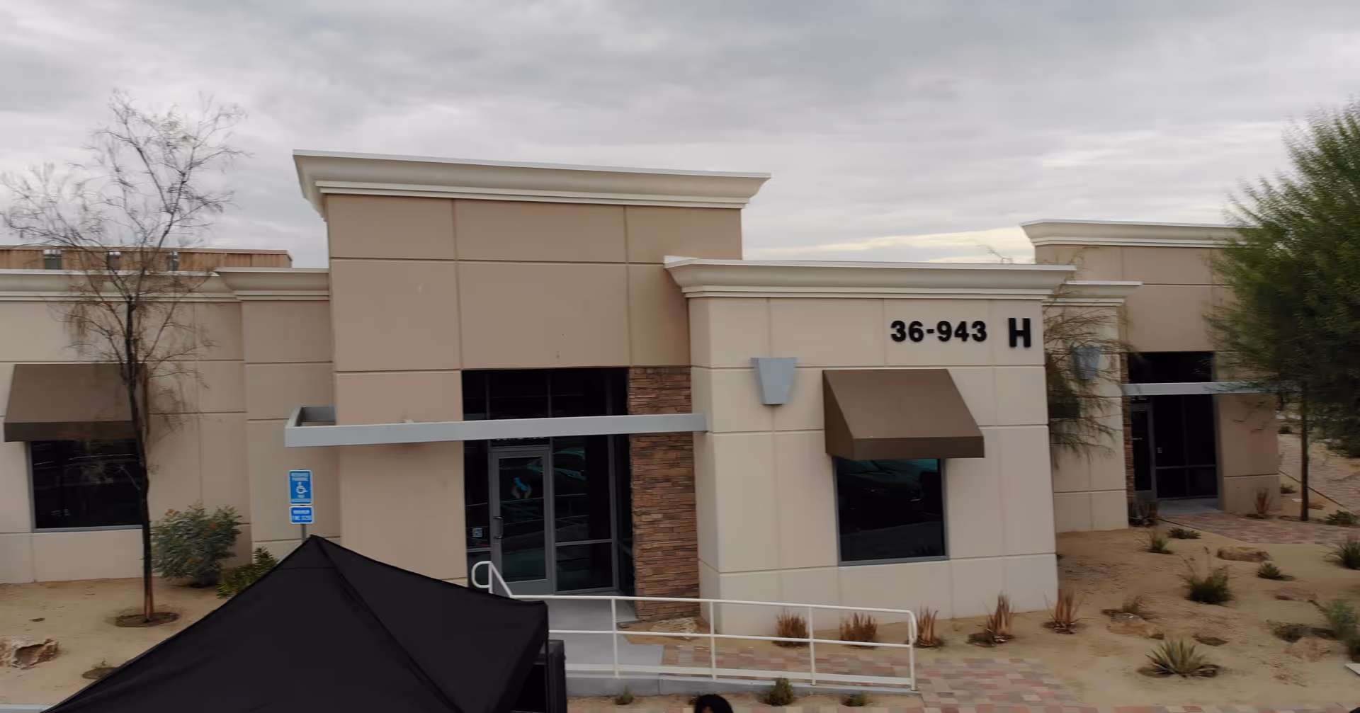 Exterior view of Inland Respite facility entrance with beige walls, brown awnings.