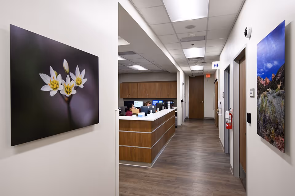 Interior hallway with a reception desk, wood cabinetry, and wall art.