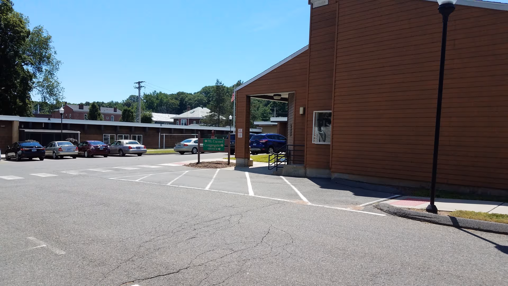 Exterior view of Mt Carmel Congregate Housing with parked cars and entrance