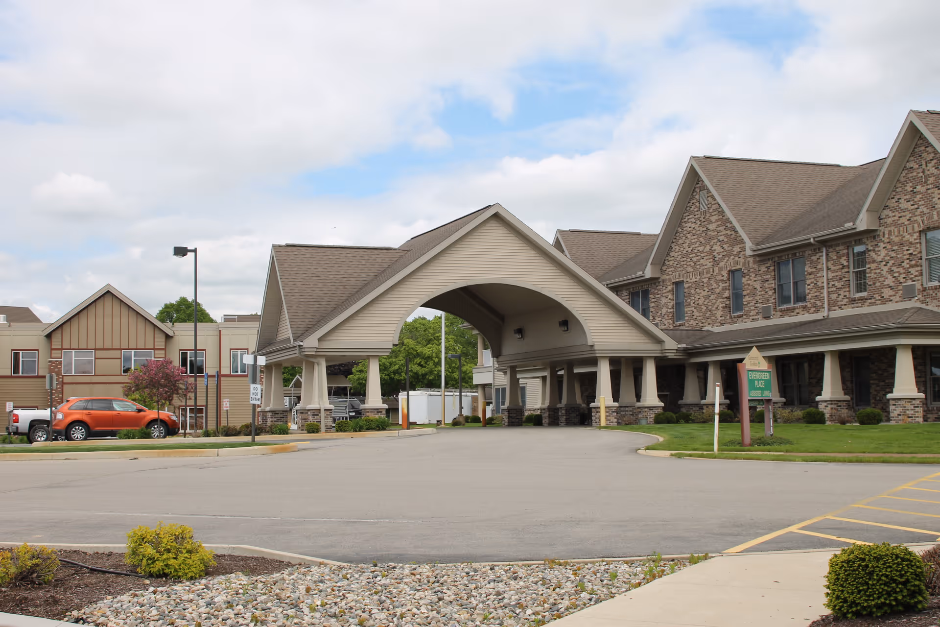 Exterior view of Greencroft Goshen with porte-cochère entrance and landscaped brick building.