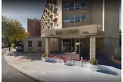 Exterior view of Elm York Assisted Living entrance with sidewalk and planters.