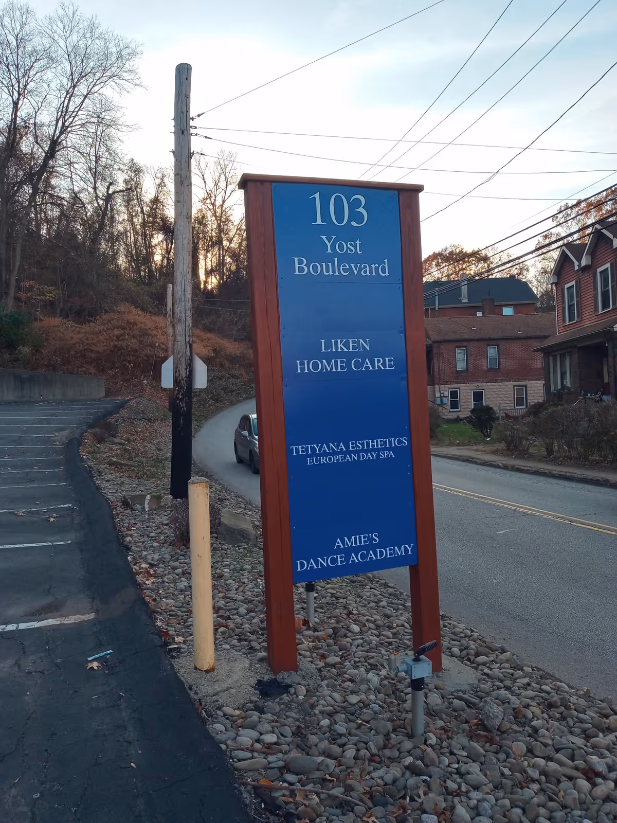 A blue vertical sign labeled 103 Yost Boulevard for Liken Home Care stands outside.