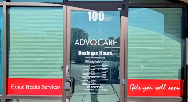 Glass front entrance with Advocare Home Health LLC signage and red banners.