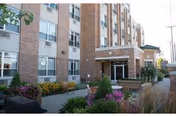 Exterior of Generations at Regency senior living facility with brick facade and landscaped entryway.