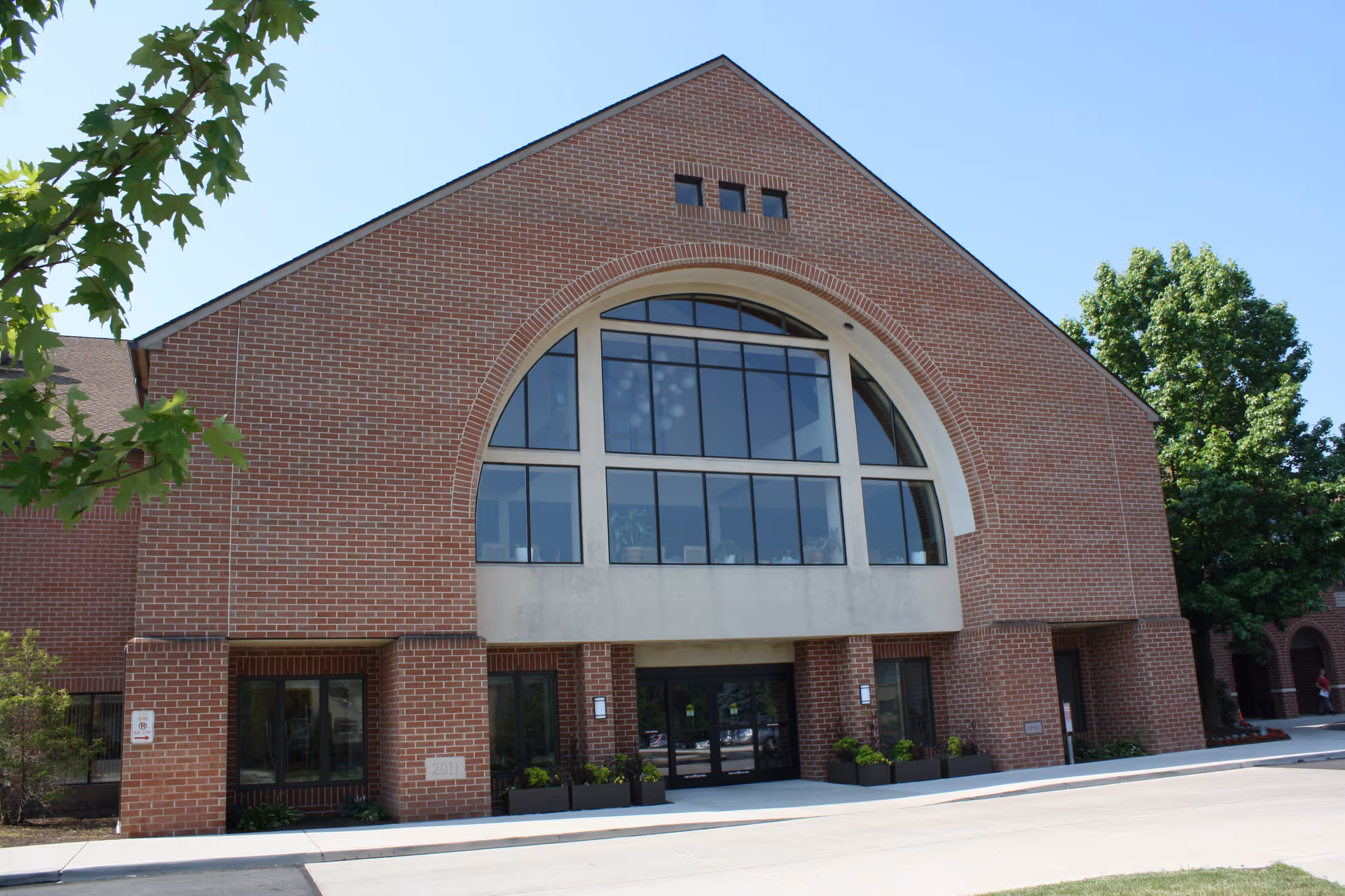 Foxdale Village exterior: brick building with a large arched window and front entrance.