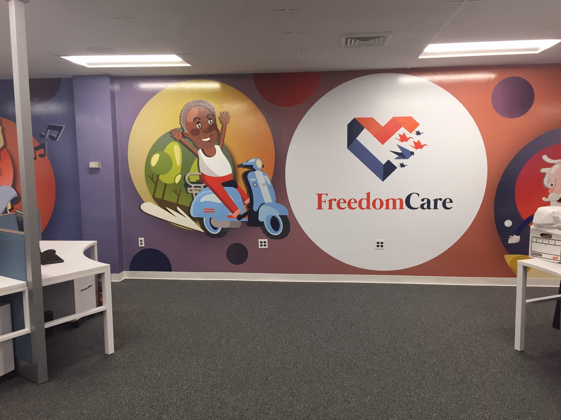 Colorful wall mural featuring the FreedomCare logo inside a bright interior.