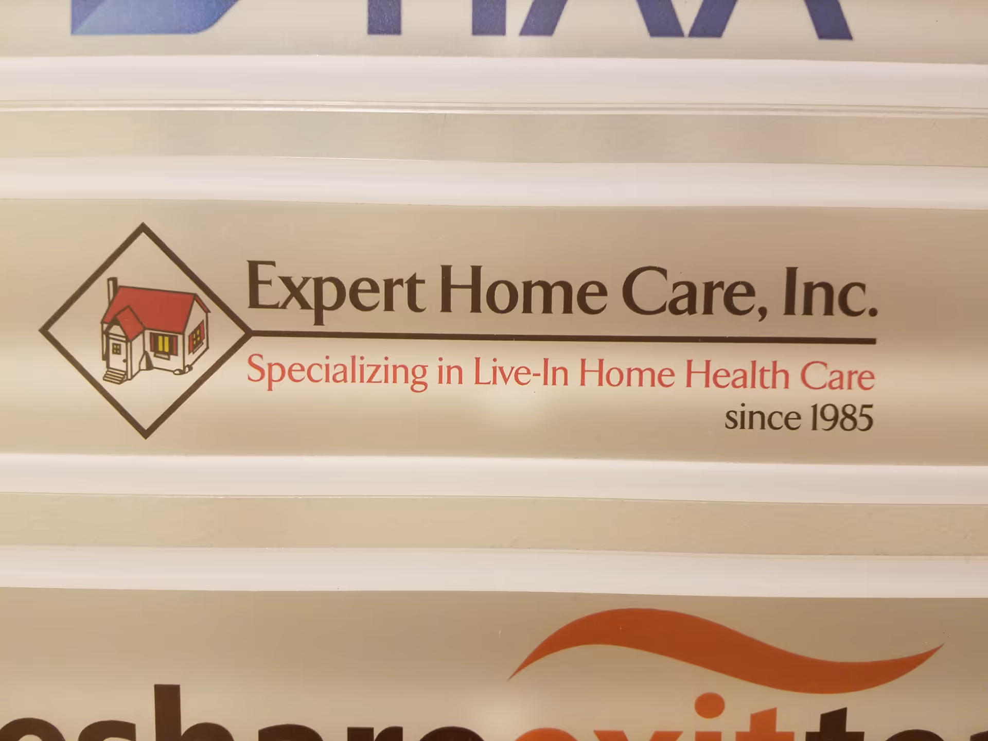 Sign with Expert Home Care, Inc. logo and text on a wall.