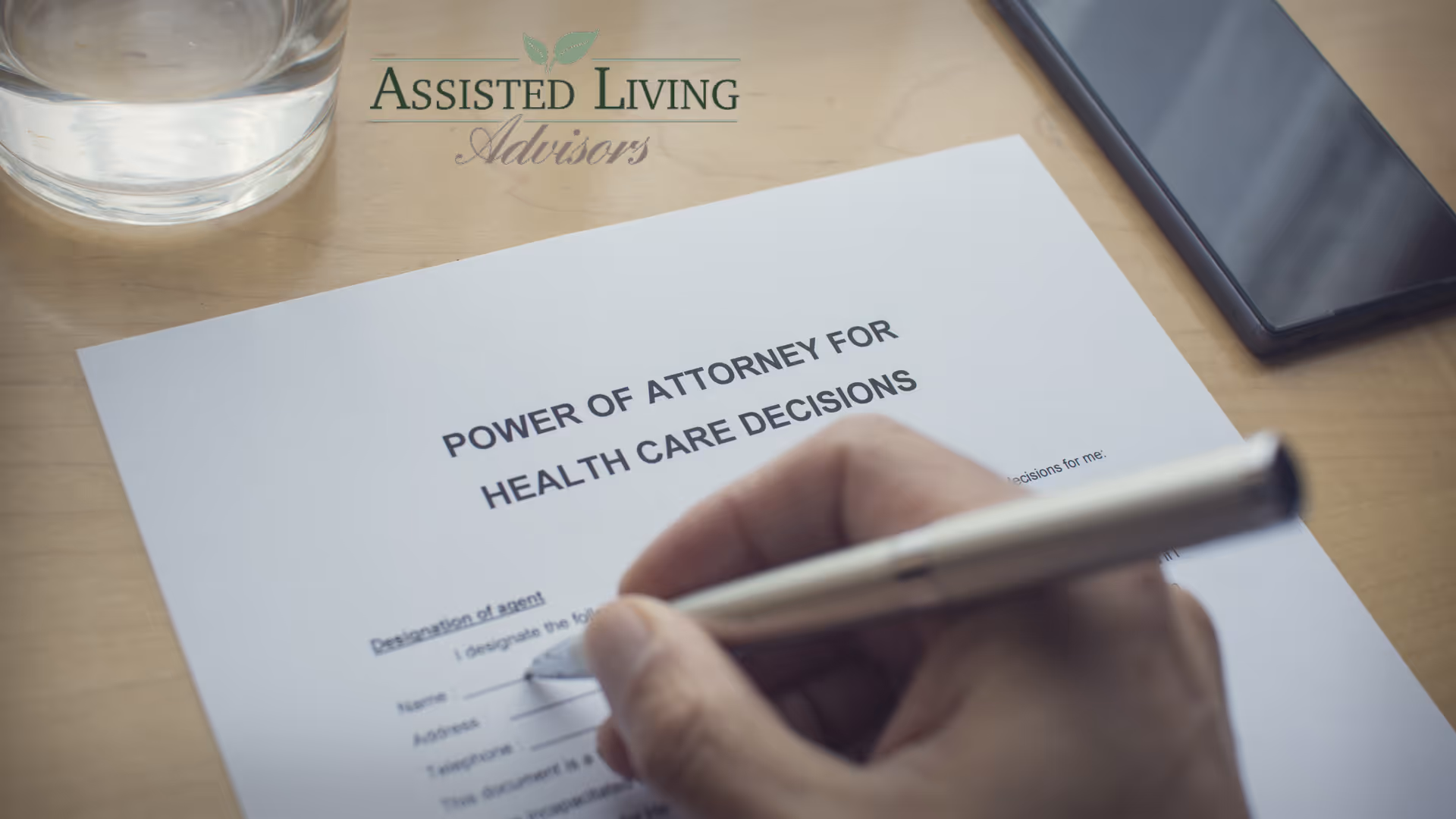 Person signs a Power of Attorney for Health Care Decisions form on a desk.