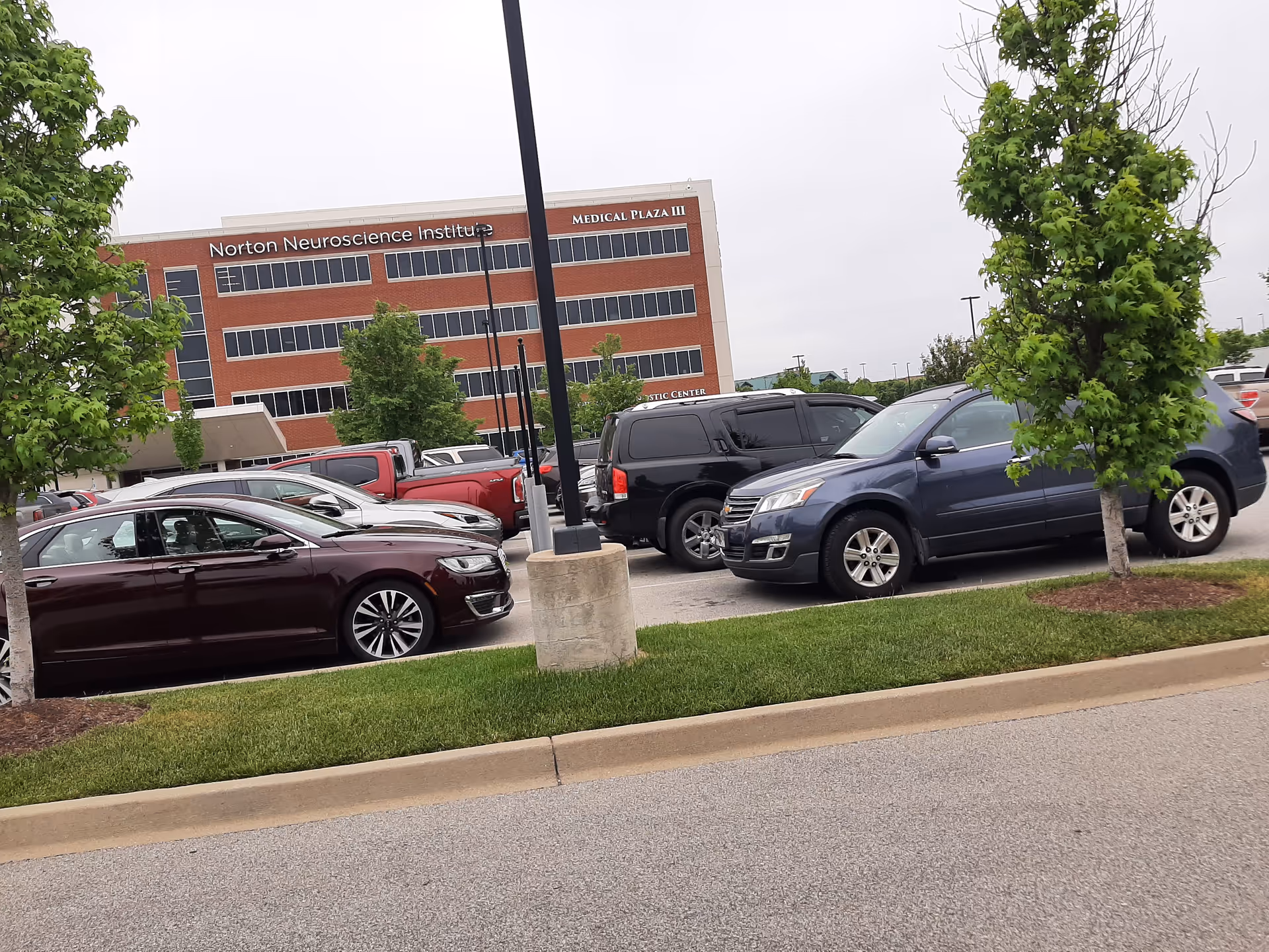 Exterior view of Norton Medical Plaza III Brownsboro with cars in a parking lot.