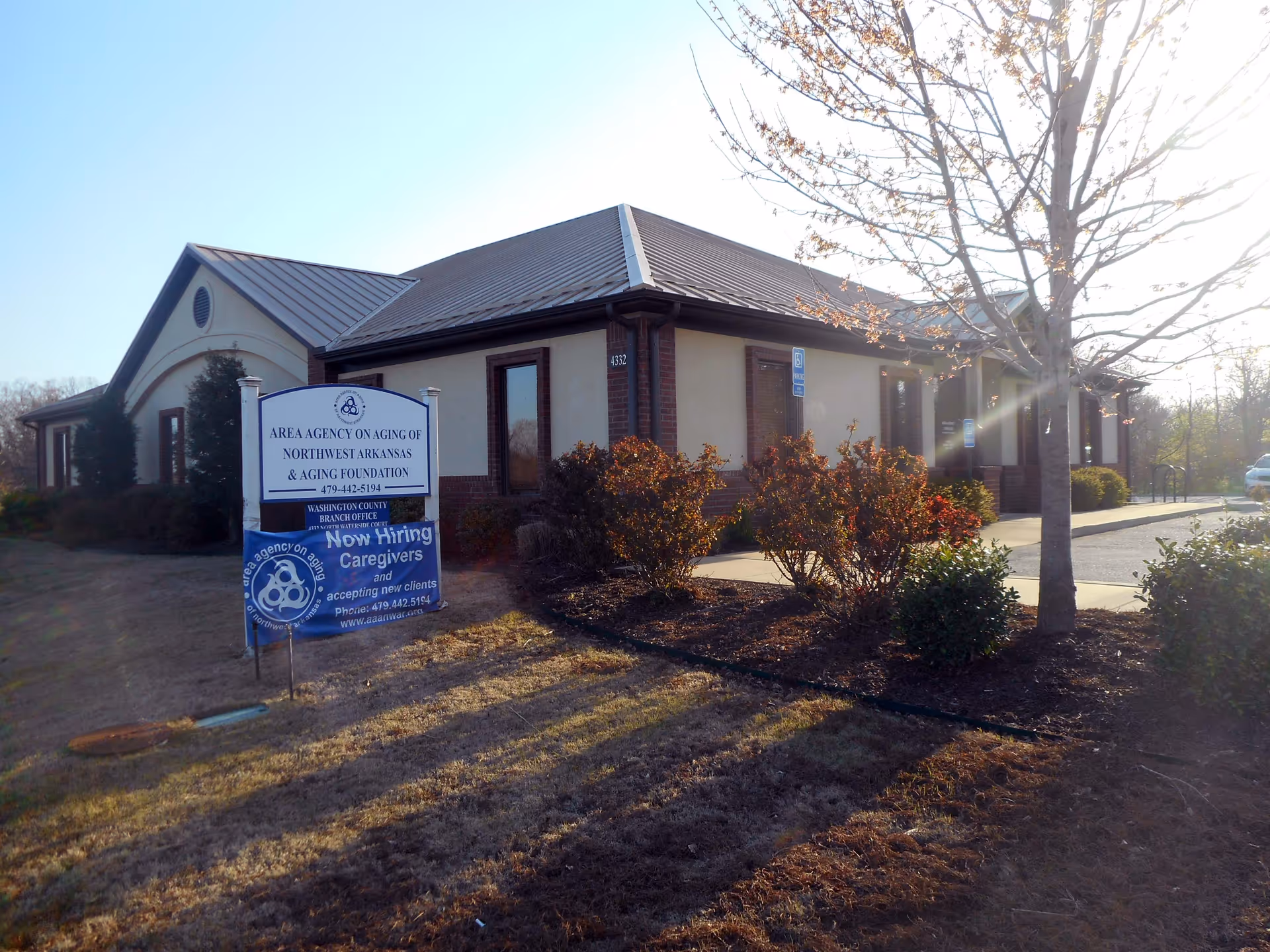Exterior of a single-story senior facility with landscaping and a sign.