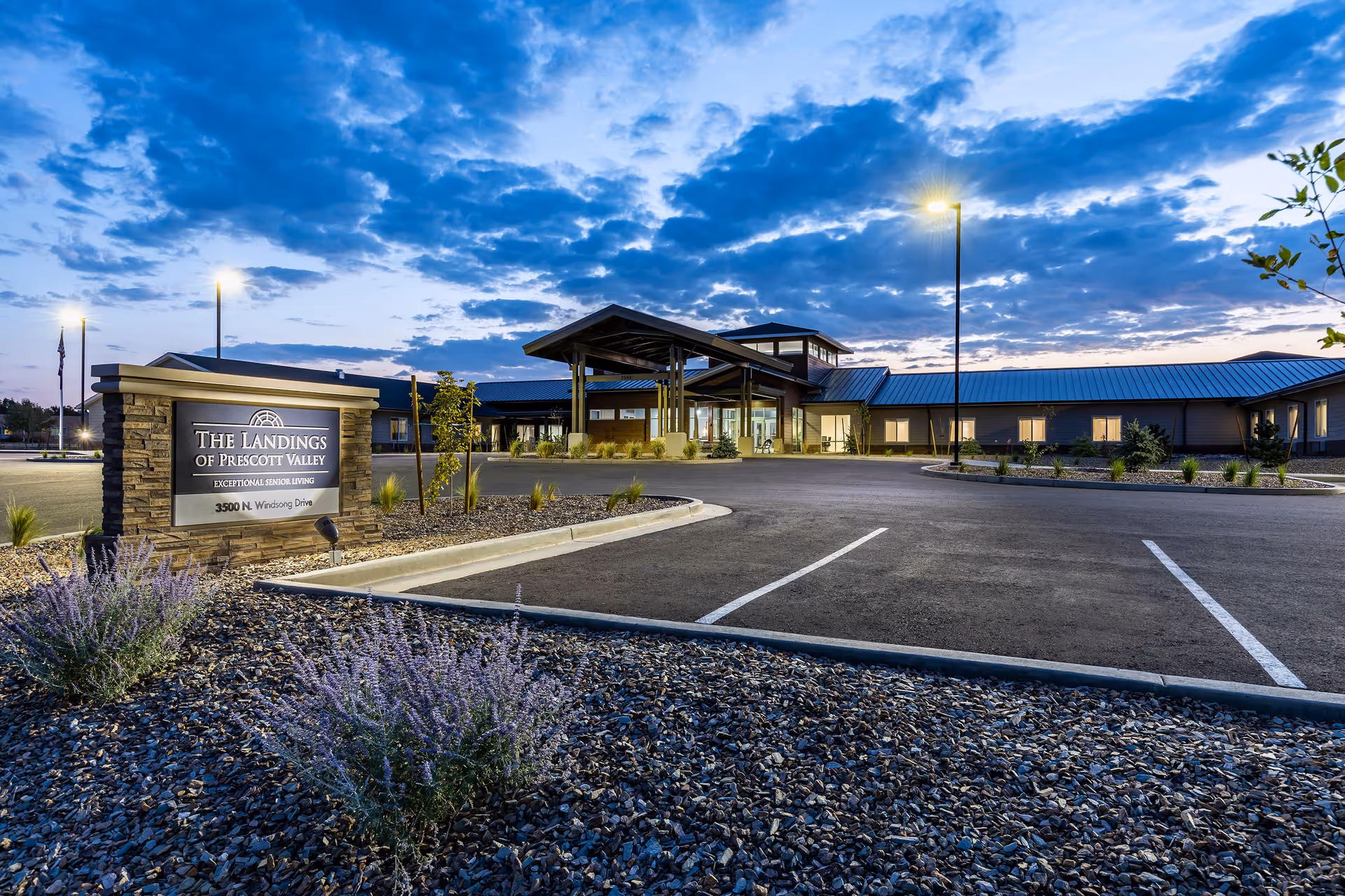 Exterior view of The Landings of Prescott Valley with sign, driveway, and illuminated entrance.