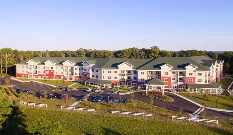 A large multi-building senior living campus with a circular driveway and parking.