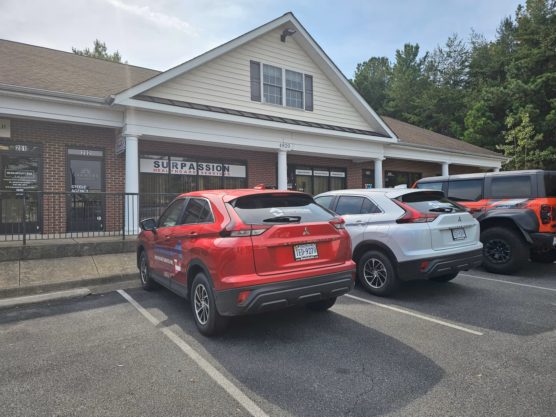 Surpassion Health Care Services building front with parked cars in lot.