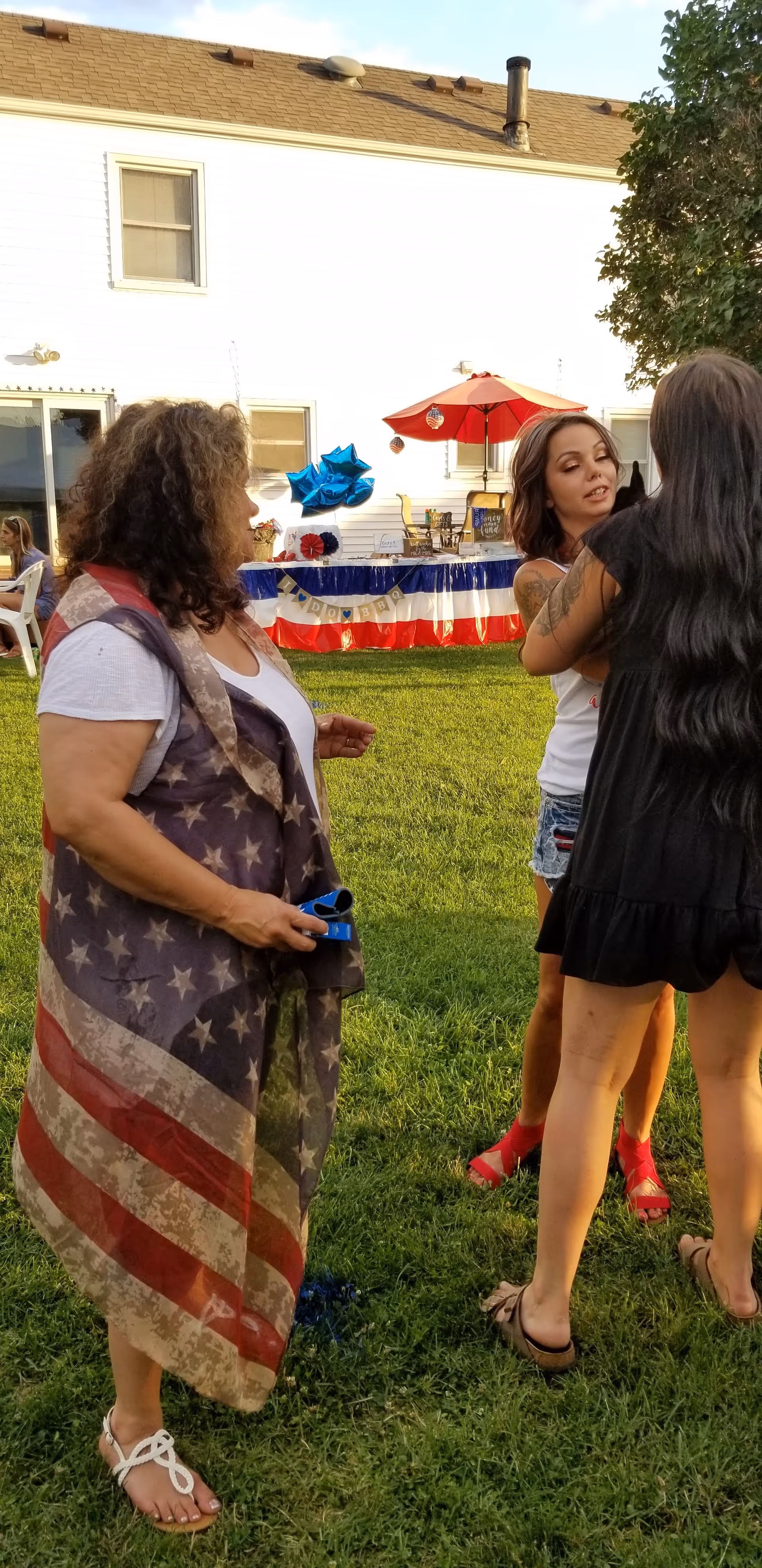 Outdoor gathering at Carter Country Homes with residents socializing near a patriotic table setup.