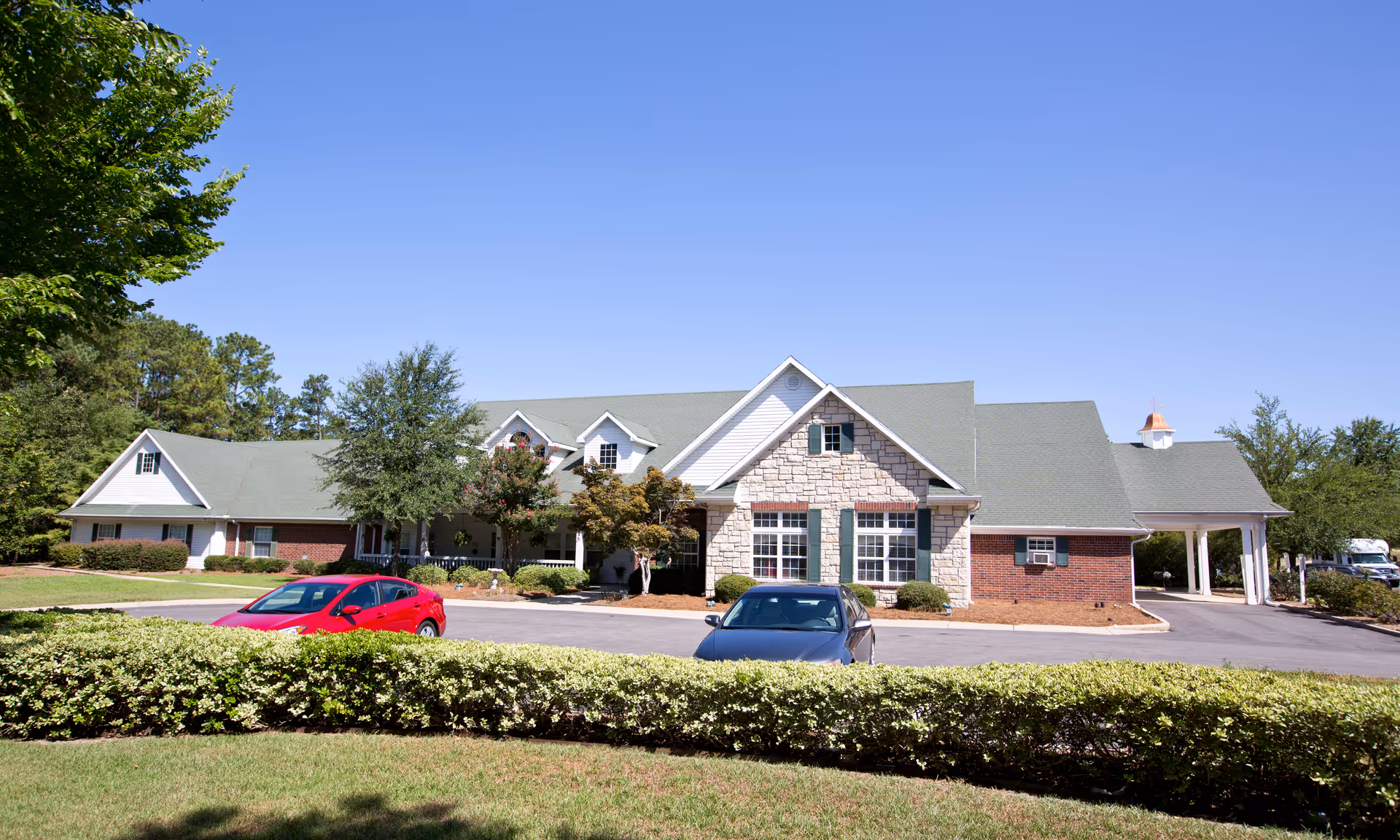 Brookdale Columbia facility exterior with brick and stone facade, landscaped grounds, parked cars.