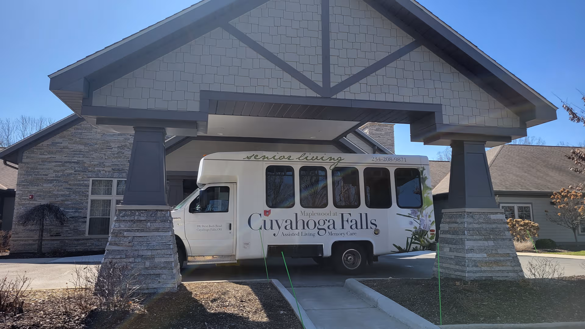 Front of Maplewood at Cuyahoga Falls with parked senior living bus.