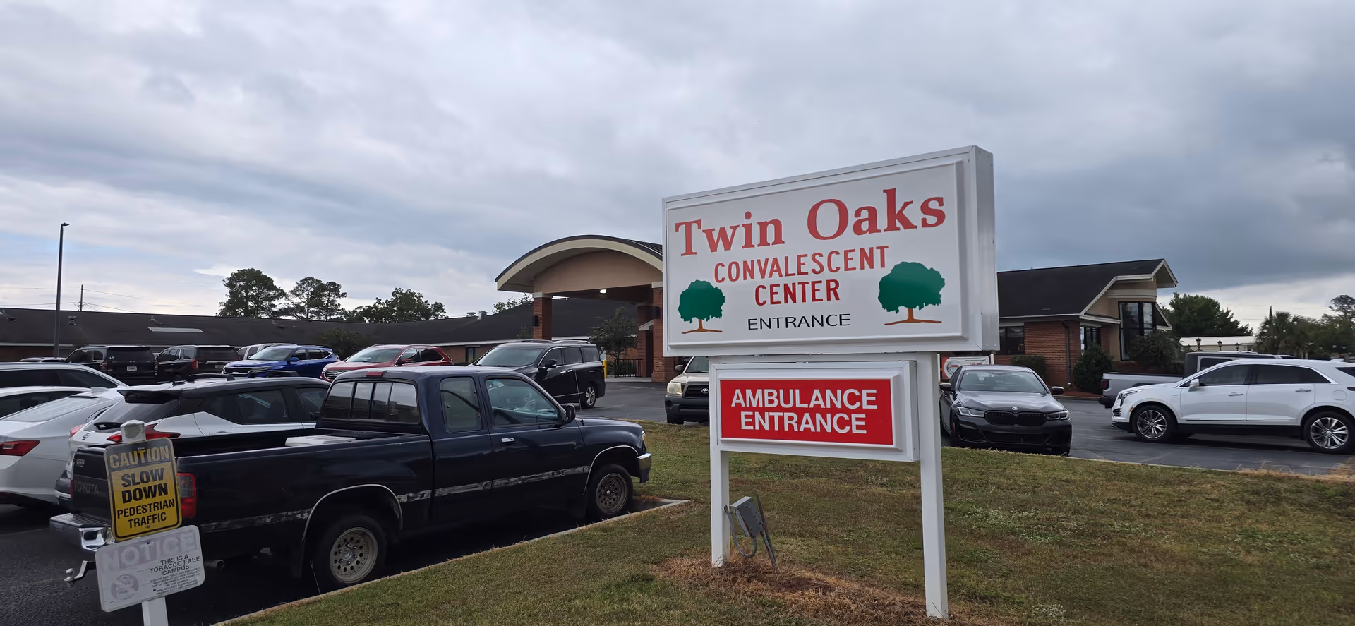 Exterior view of Twin Oaks Convalescent Center with parking lot.