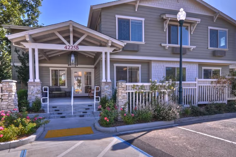 Front view of Ivy Park at Santa Rosa with covered entrance, steps, and landscaped garden beds.