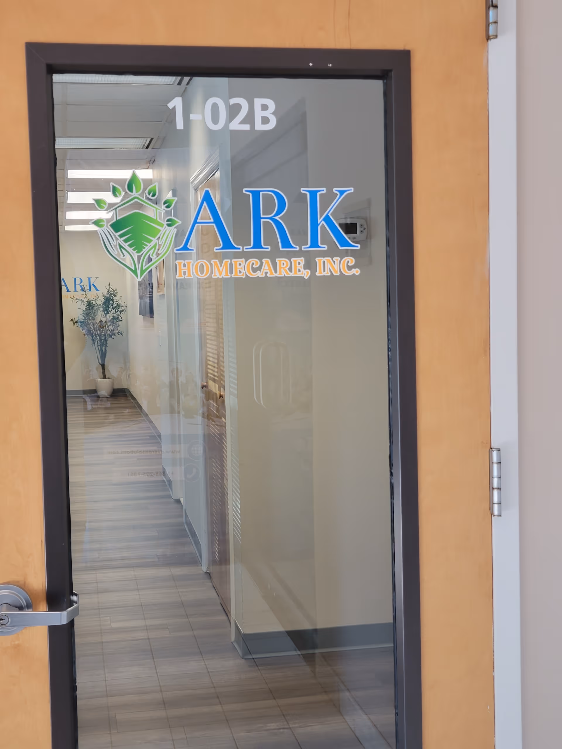 Glass door with ARK HOMECARE INC logo opens to a hallway.