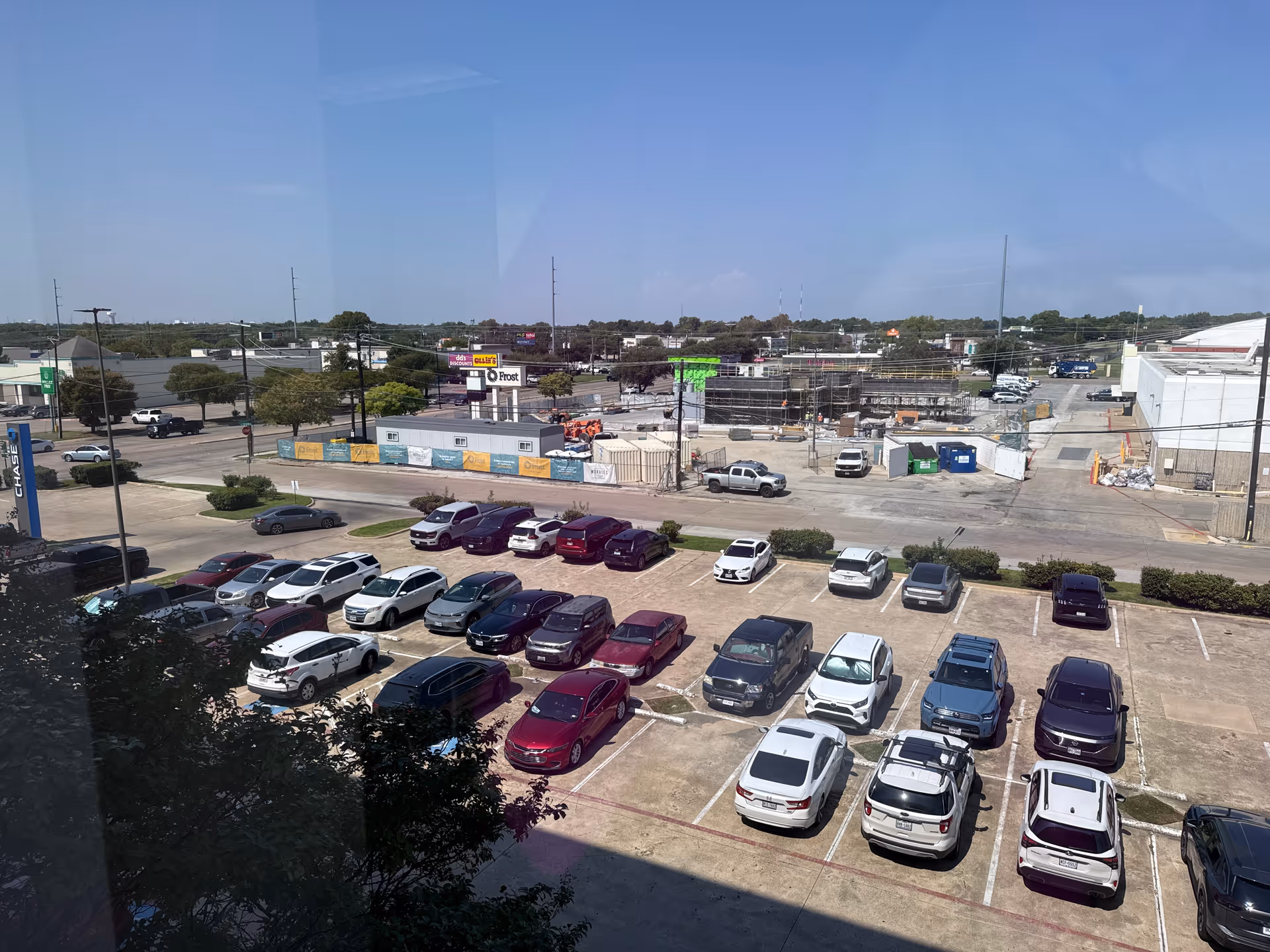 Exterior view of a busy parking lot with a distant construction site.