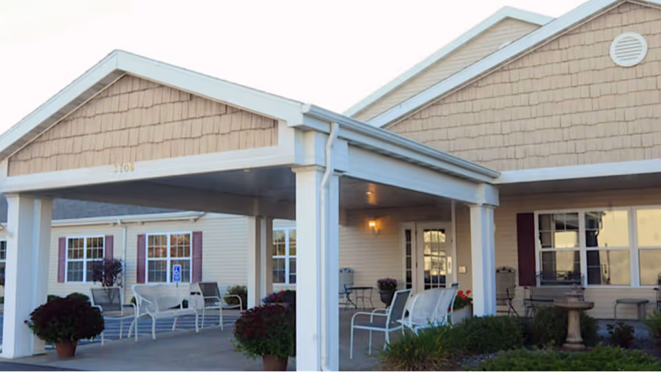 Front entrance of Heritage Senior Living at Oakwood Hills with a covered porch and seating.
