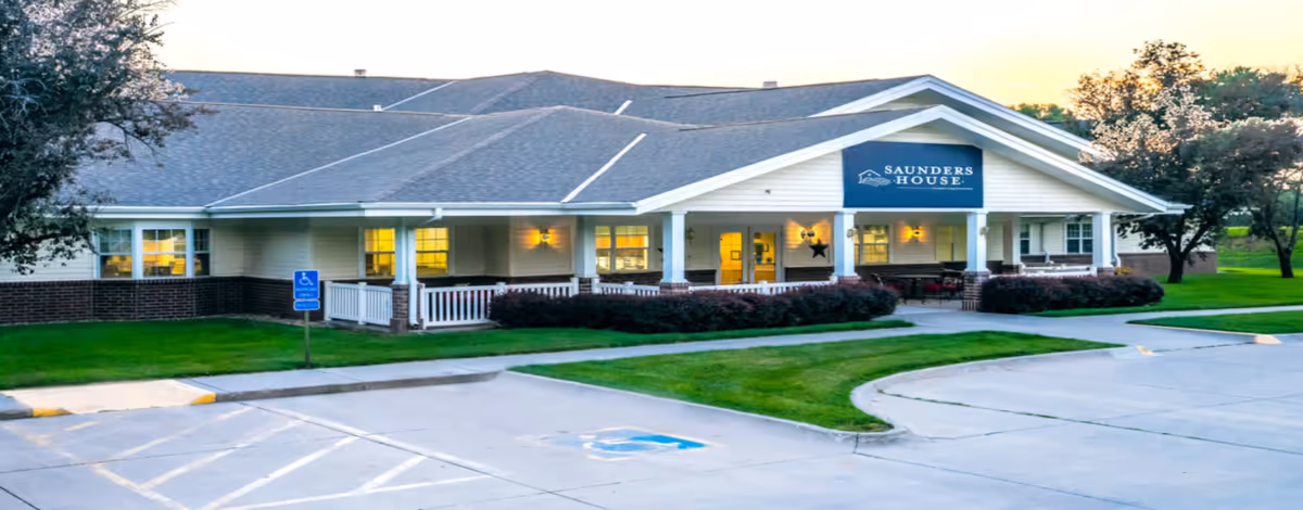 Exterior view of Saunders House senior living facility with porch and parking lot