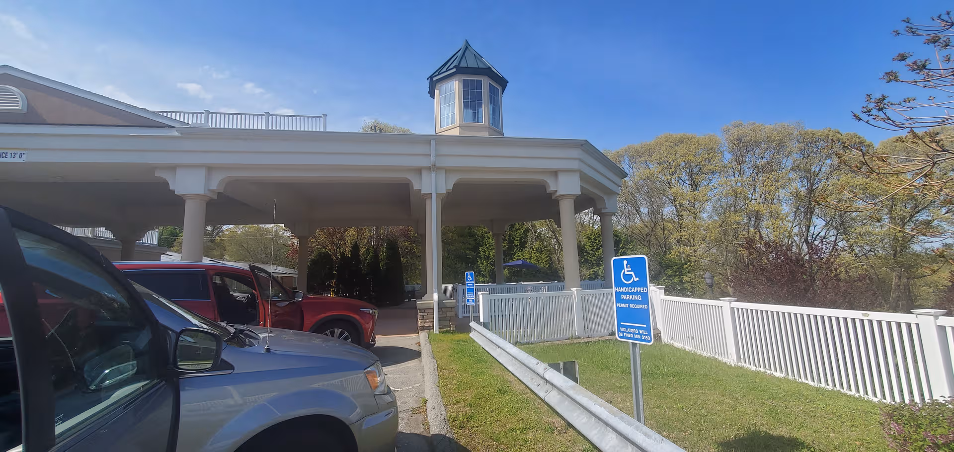 Front entrance of Mystic Healthcare with a covered driveway and parked cars.
