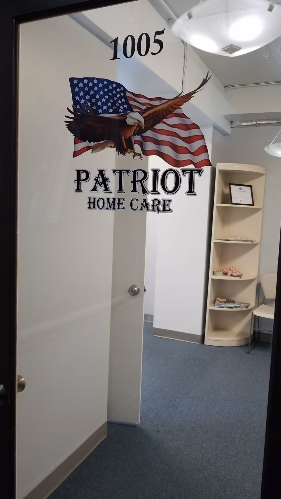 Interior hallway with Patriot Home Care logo, American eagle mural, and a bookshelf along the wall.