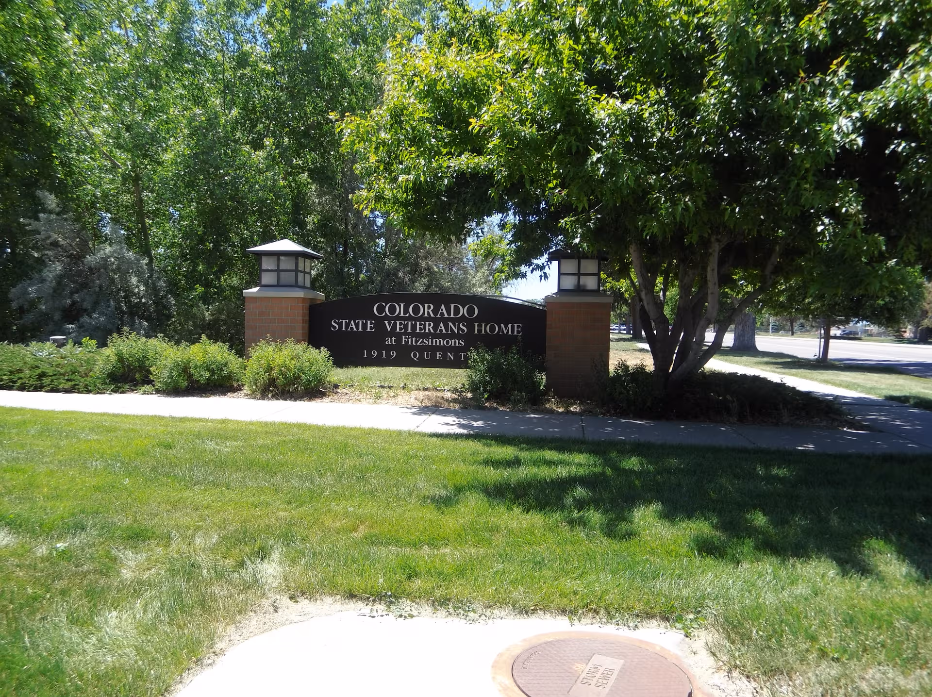 Entrance sign reads Colorado State Veterans Home at Fitzsimmons amid trees and lawn