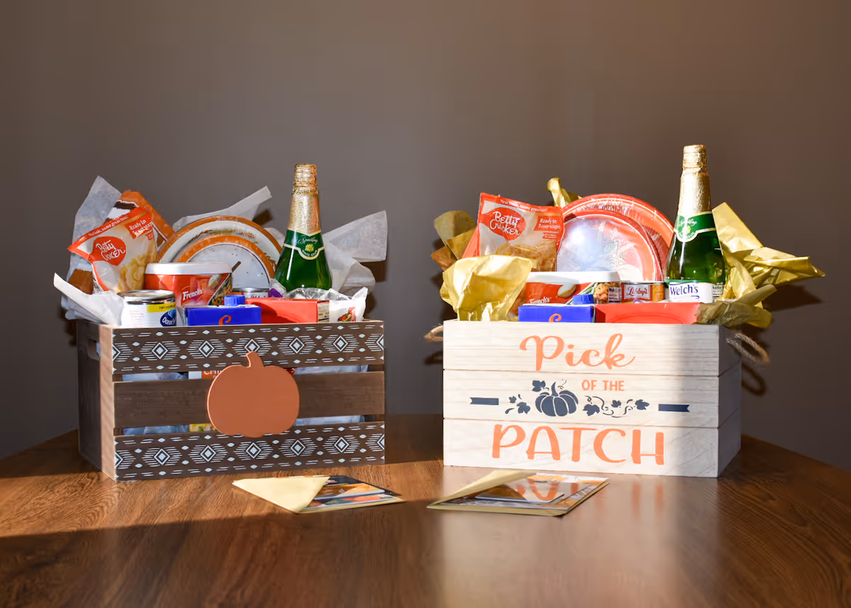 Two wooden crates with snacks and bottles rest on a wooden table.