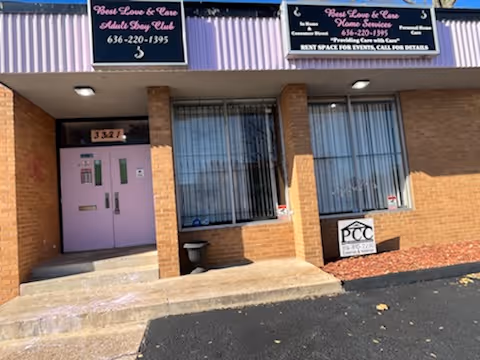 Exterior brick building with purple entrance doors and facility signage.