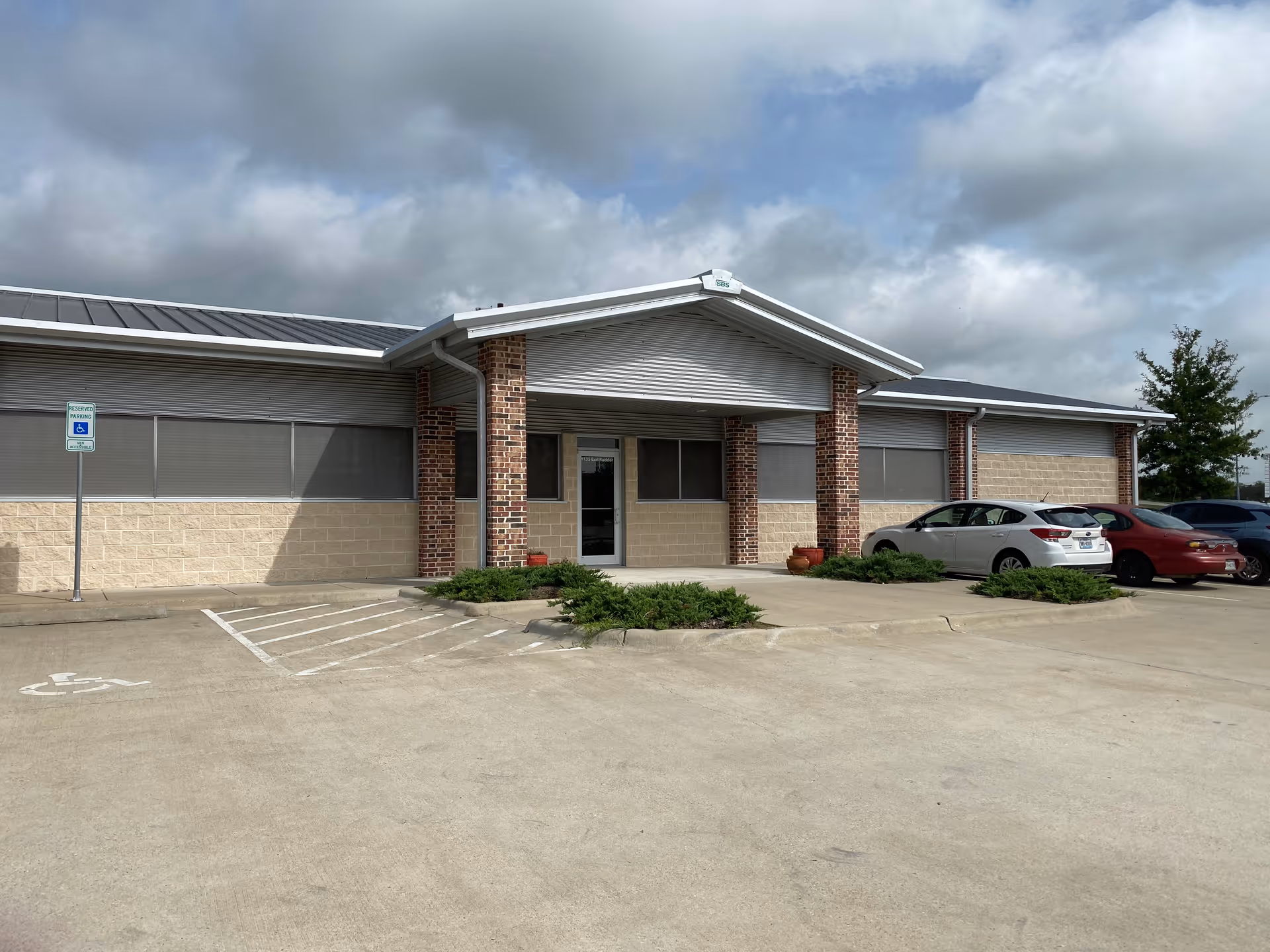 Exterior view of a single-story care facility with brick columns and a covered entrance.