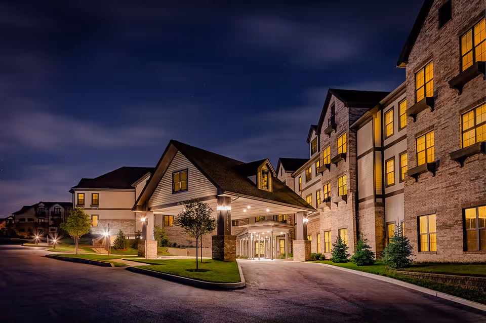 Night exterior view of The Wellstone House entrance with illuminated windows and drive-up canopy.