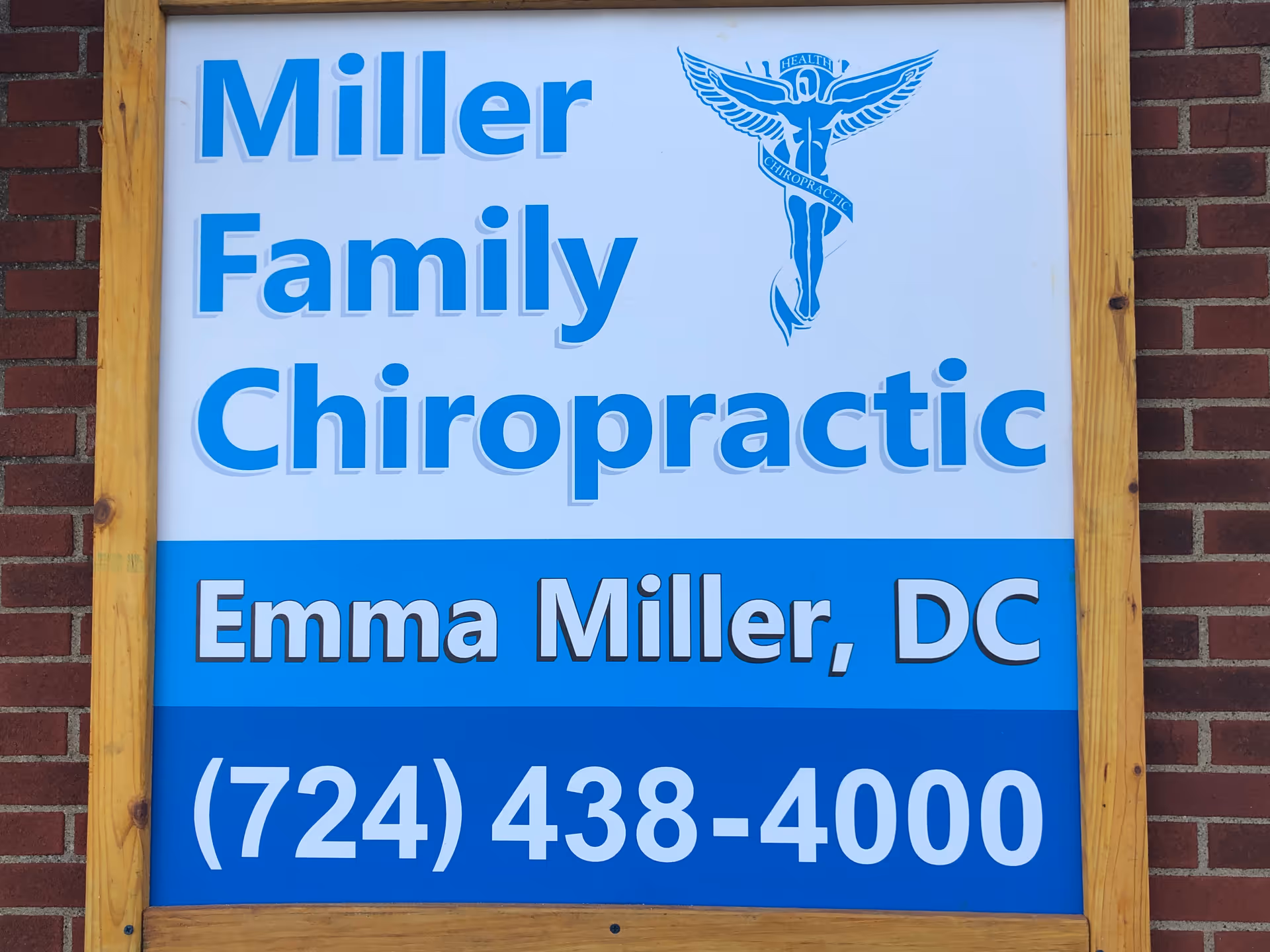 Signboard outside a brick building reads Miller Family Chiropractic and Emma Miller, DC.